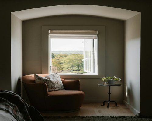 A calm and quiet reading corner near a window with a comfortable chair
